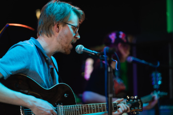 jongeman zingt terwijl hij gitaar speelt